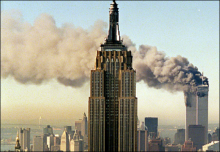The twin towers of the World Trade Center burn behind New York's Empire State Building. (AP Photo/Marty Lederhandler)
